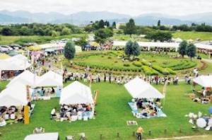 たくさんの白いテントのぼり旗や人で賑わいをみせている、最上川せせらぎ公園内広場にて実施された元祖芋煮会㏌中山の写真