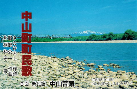 遠くには雪を被った山が見え、手前には大小の石が転がる川岸と静かに流れる川、その奥には緑の木々と鉄橋が写る中山町町民歌の表紙写真