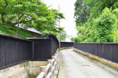旧柏倉家住宅を中心に、両側に奥へと続く黒塀がありその間にきれいに整備された通路が写っている写真