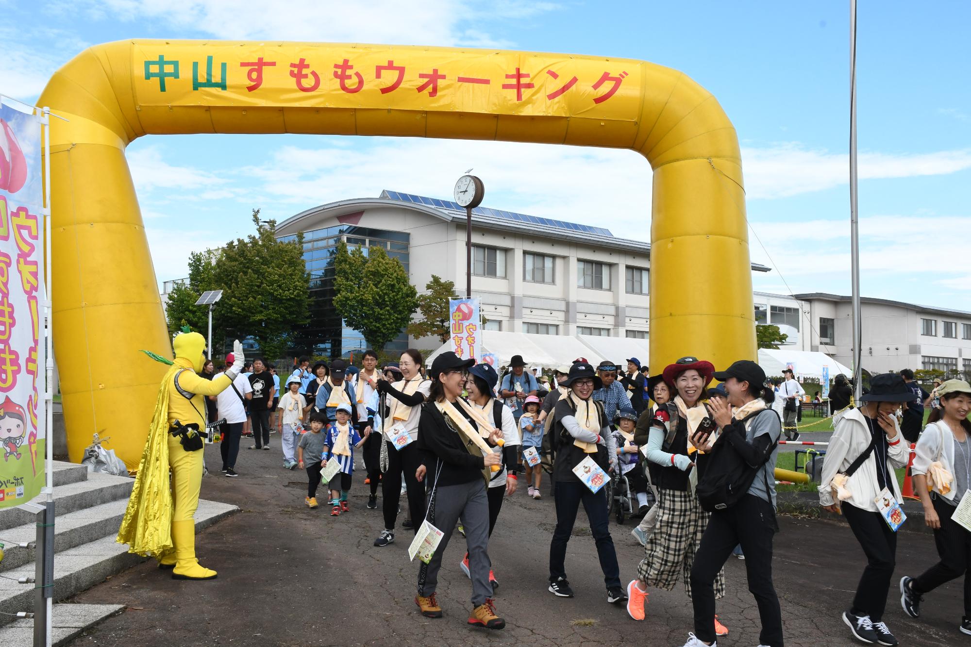 旧柏倉家住宅前の歩道でたくさんの参加者がウォーキングを楽しんでいる写真